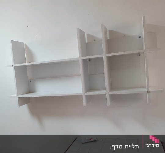 מדף קיר לבן מותקן על קיר לבן